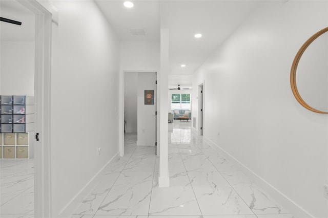 corridor featuring recessed lighting, marble finish floor, and baseboards