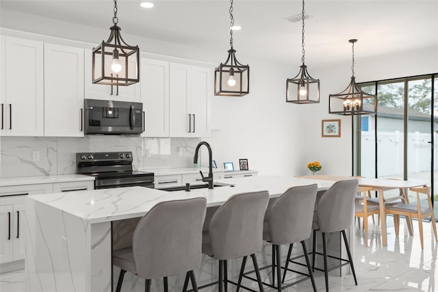 kitchen featuring appliances with stainless steel finishes, marble finish floor, a kitchen island with sink, and a sink