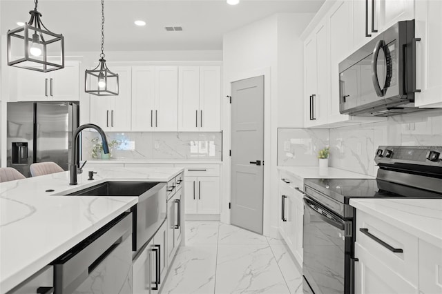 kitchen with marble finish floor, pendant lighting, recessed lighting, appliances with stainless steel finishes, and a sink