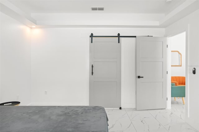 unfurnished bedroom featuring marble finish floor, a barn door, and visible vents