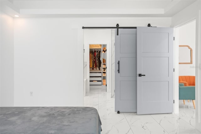 bedroom featuring a barn door, recessed lighting, marble finish floor, a spacious closet, and a closet