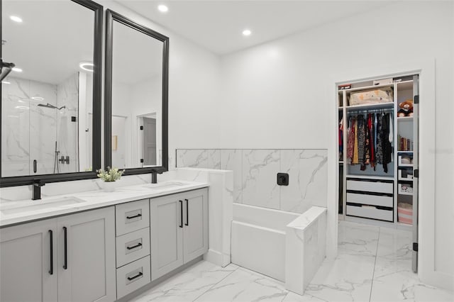 bathroom with marble finish floor, a sink, a marble finish shower, and a walk in closet