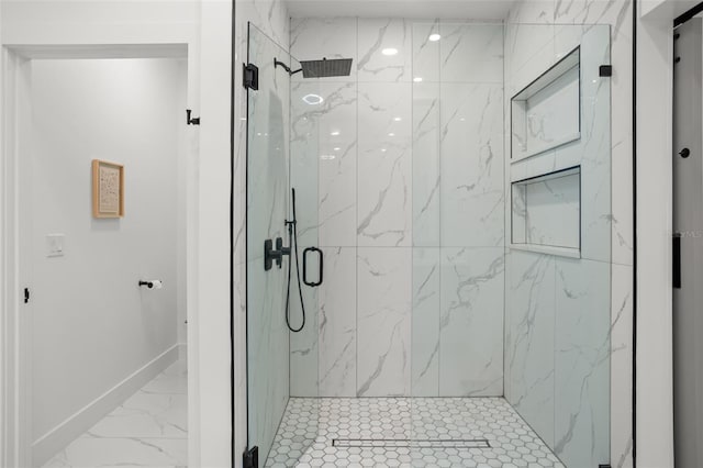 bathroom with marble finish floor, baseboards, and a marble finish shower