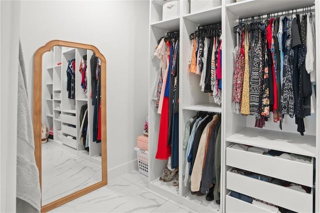 walk in closet featuring marble finish floor