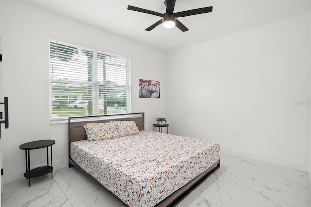 bedroom with ceiling fan, marble finish floor, and baseboards