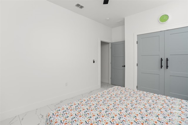 bedroom featuring ceiling fan, visible vents, baseboards, marble finish floor, and a closet