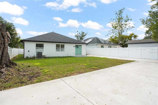 rear view of house with driveway, a lawn, a patio, a fenced backyard, and central air condition unit