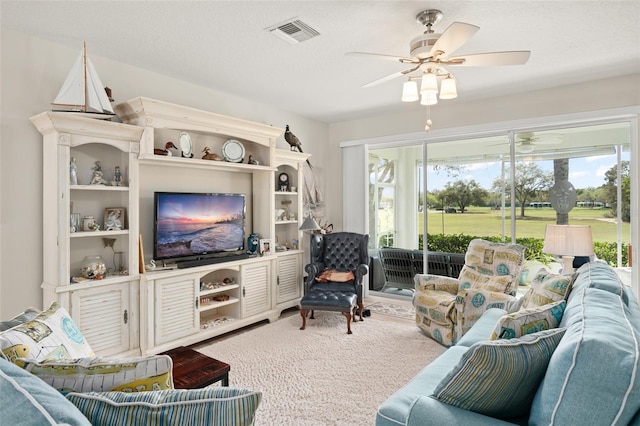 carpeted living area with visible vents, a textured ceiling, and ceiling fan