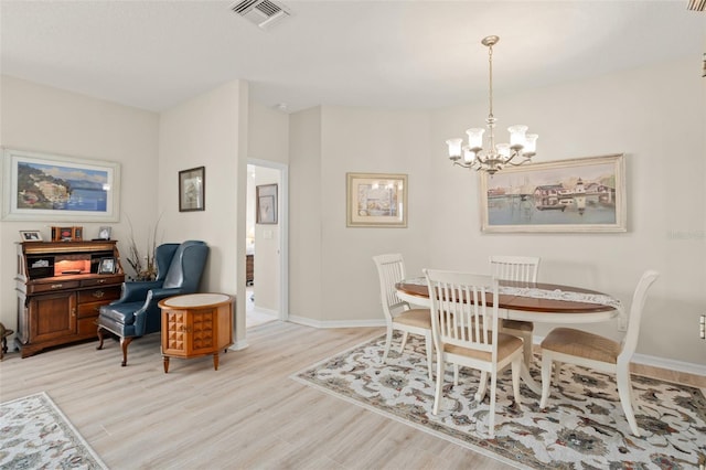 dining room with an inviting chandelier, light wood-style floors, visible vents, and baseboards