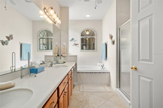 bathroom with a ceiling fan, a sink, tile patterned flooring, a shower stall, and a bath