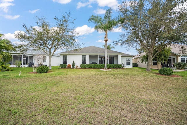 rear view of property featuring a yard and stucco siding