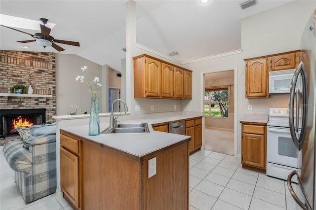 kitchen with light tile patterned floors, stainless steel appliances, lofted ceiling, a sink, and a peninsula