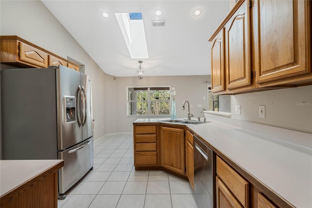 kitchen featuring light tile patterned floors, stainless steel appliances, a sink, visible vents, and brown cabinetry