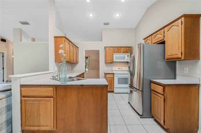 kitchen with light tile patterned floors, a peninsula, white appliances, a sink, and visible vents