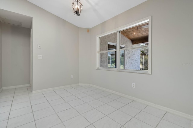 empty room with light tile patterned floors and baseboards