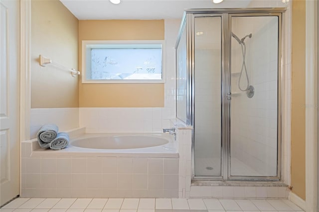 bathroom featuring tile patterned flooring, a shower stall, and a bath