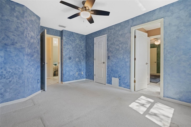 unfurnished bedroom featuring wallpapered walls, baseboards, visible vents, ceiling fan, and carpet flooring