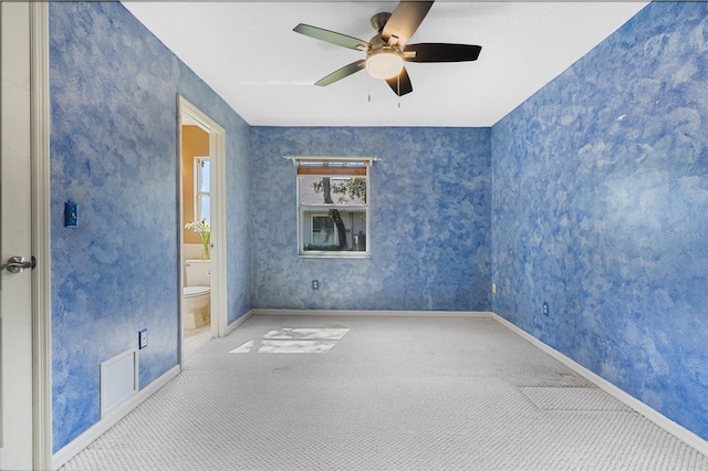 carpeted empty room with wallpapered walls, baseboards, and a ceiling fan