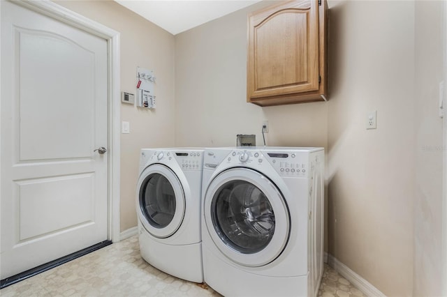 laundry area with light floors, washing machine and dryer, cabinet space, and baseboards