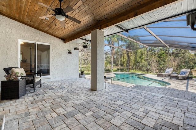 view of patio / terrace with a ceiling fan, glass enclosure, and an outdoor pool