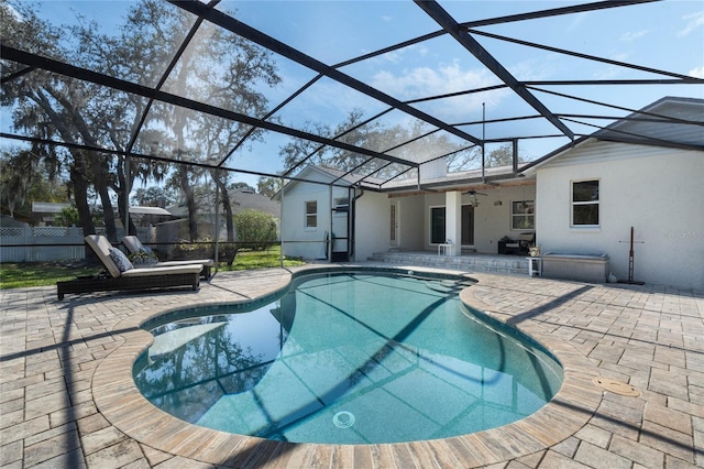 outdoor pool featuring a patio area, ceiling fan, and glass enclosure