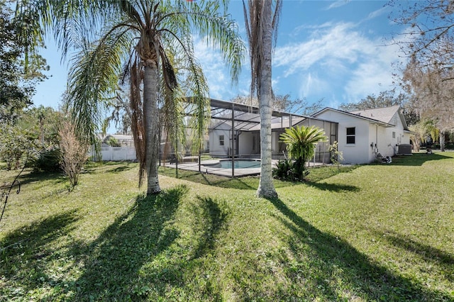 view of yard with a lanai, central air condition unit, fence, and an outdoor pool