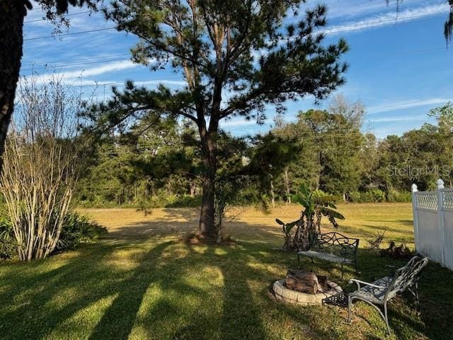 view of yard with fence and a fire pit