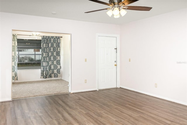 empty room featuring ceiling fan, baseboards, and wood finished floors