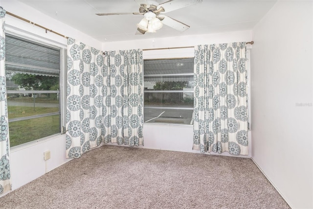 carpeted spare room with a ceiling fan