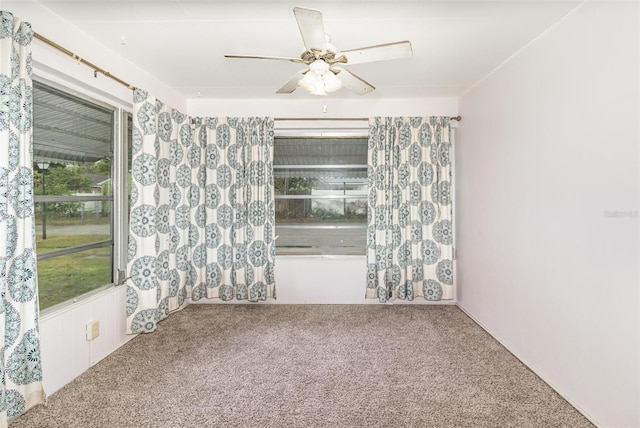 carpeted empty room with a ceiling fan