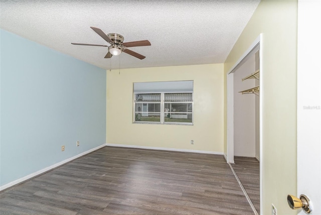 unfurnished bedroom with a closet, a textured ceiling, baseboards, and wood finished floors