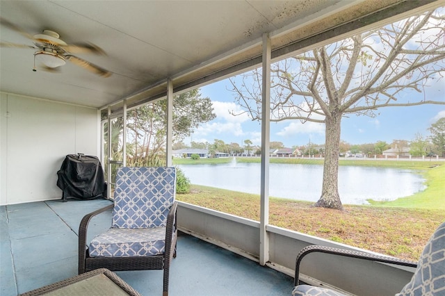 sunroom with plenty of natural light, ceiling fan, and a water view