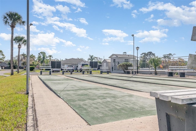 view of community featuring shuffleboard and fence