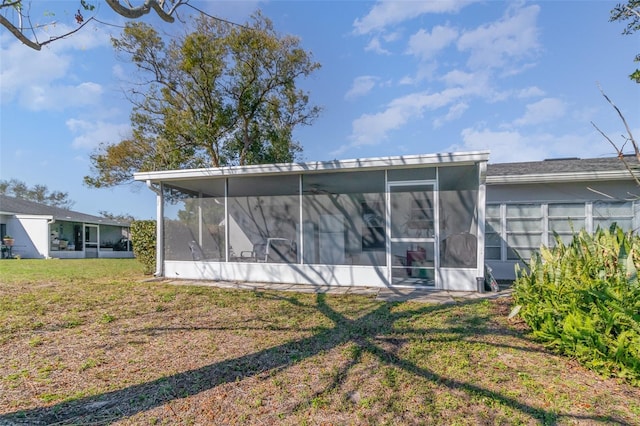 back of house with a yard and a sunroom