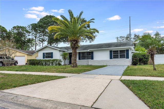 single story home with driveway, an attached garage, fence, a front yard, and stucco siding