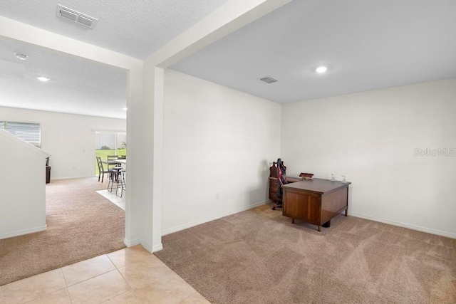 office with light carpet, light tile patterned flooring, visible vents, and baseboards