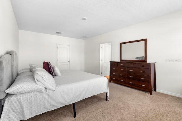 bedroom with light carpet, visible vents, and baseboards