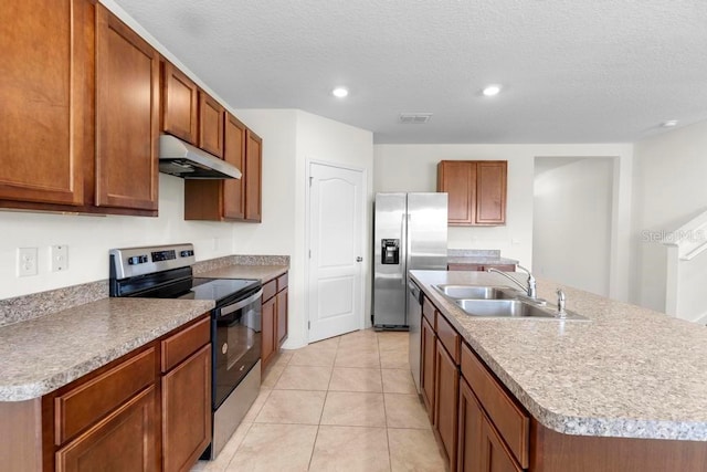 kitchen featuring stainless steel appliances, visible vents, a sink, an island with sink, and under cabinet range hood