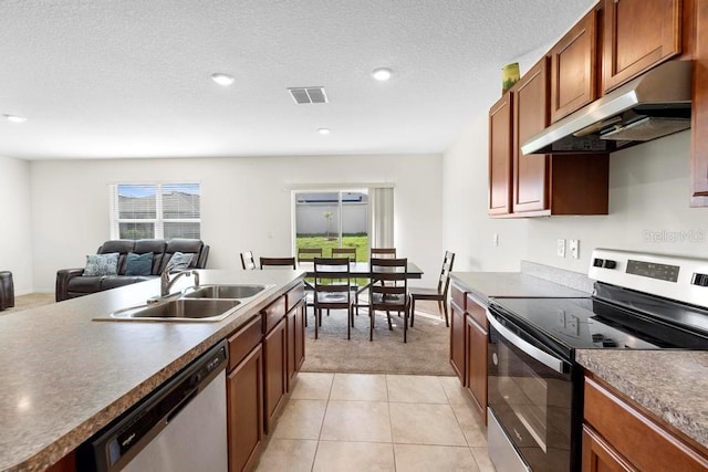 kitchen featuring visible vents, appliances with stainless steel finishes, open floor plan, under cabinet range hood, and a sink