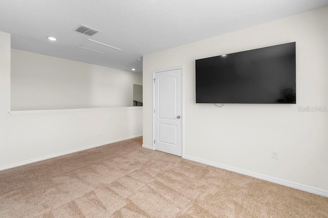 empty room featuring recessed lighting, light colored carpet, visible vents, attic access, and baseboards