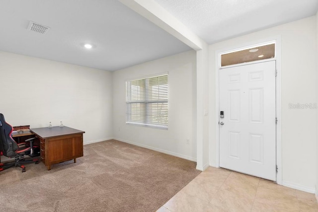 entryway featuring light carpet, visible vents, baseboards, and light tile patterned flooring