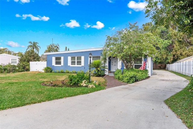 view of front of house with fence, a front lawn, concrete driveway, and stucco siding