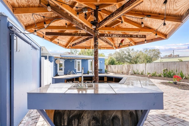 view of patio with a sink and fence