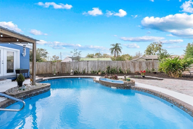 view of pool with a pool with connected hot tub, french doors, a fenced backyard, and a patio