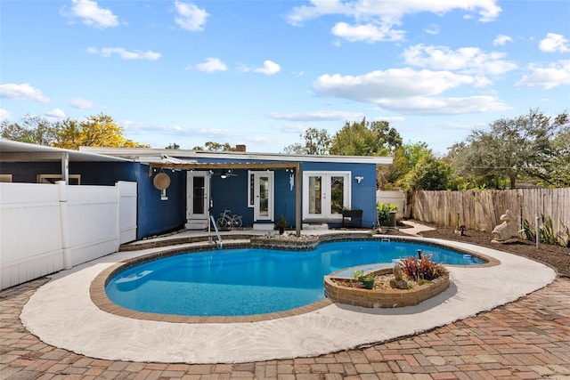 view of swimming pool featuring a patio, french doors, a fenced backyard, and a fenced in pool