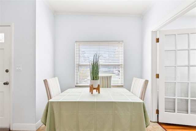 dining room with ornamental molding and baseboards