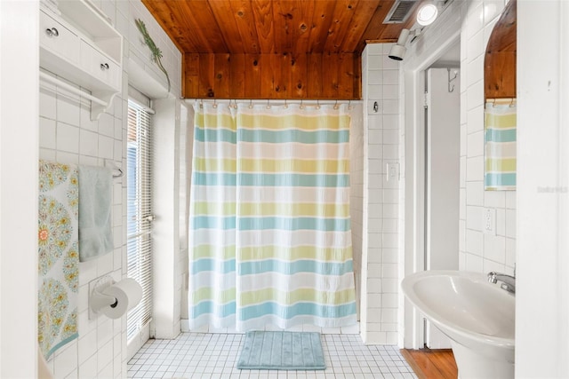 bathroom featuring wooden ceiling, tile patterned flooring, a shower with shower curtain, visible vents, and tile walls