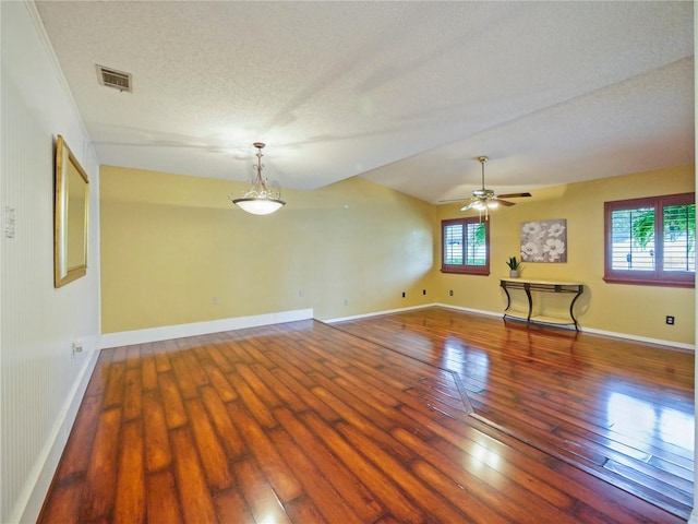 spare room featuring a textured ceiling, hardwood / wood-style flooring, plenty of natural light, and visible vents