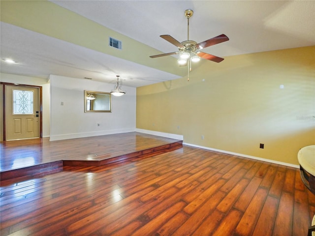 spare room with a ceiling fan, hardwood / wood-style flooring, visible vents, and baseboards