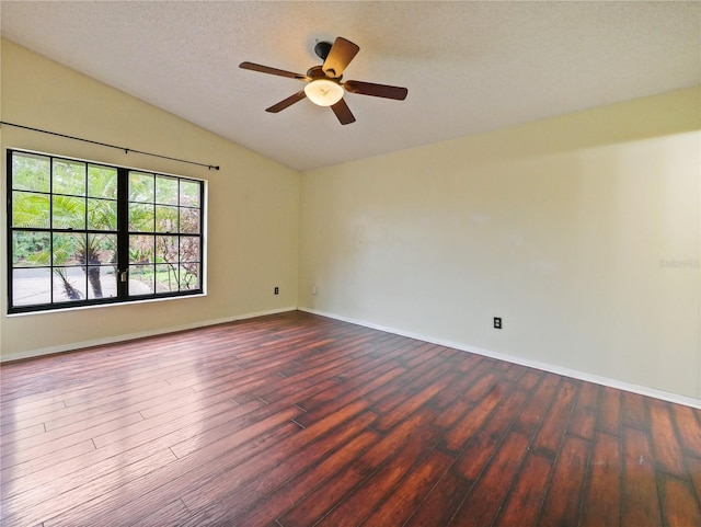 empty room featuring baseboards, a ceiling fan, lofted ceiling, wood finished floors, and a textured ceiling